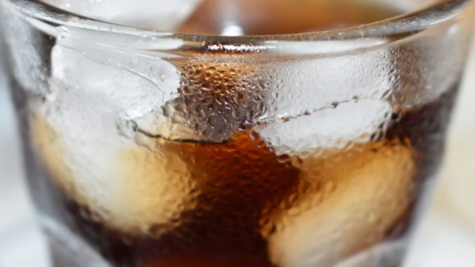 Erfrischender Genuss: Ein Glas Cola mit Eiswürfeln.